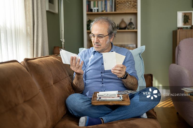 一名有阿尔茨海默病风险的男子看着旧照片图片素材