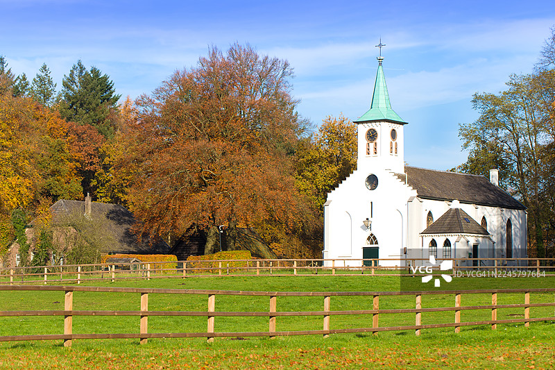 位于海尔德兰省韦吕沃地区亨德勒洛的赫尔德林教堂，周围环绕着秋叶。图片素材