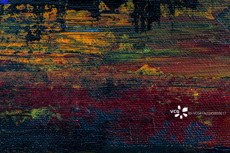 抽象的黑色、橙色、红色和蓝色丙烯颜料背景的宏观特写。图片素材