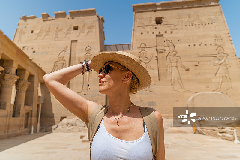 埃及阿斯旺的菲莱神庙（又称伊西斯神庙），位于阿吉基亚岛上，一位女士正在散步图片素材