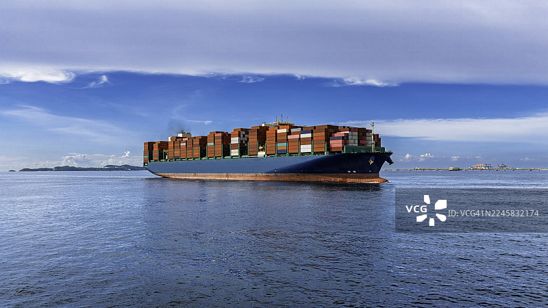 海面上集装箱货船的全景视图，集装箱堆叠在商业港口的码头上。图片素材