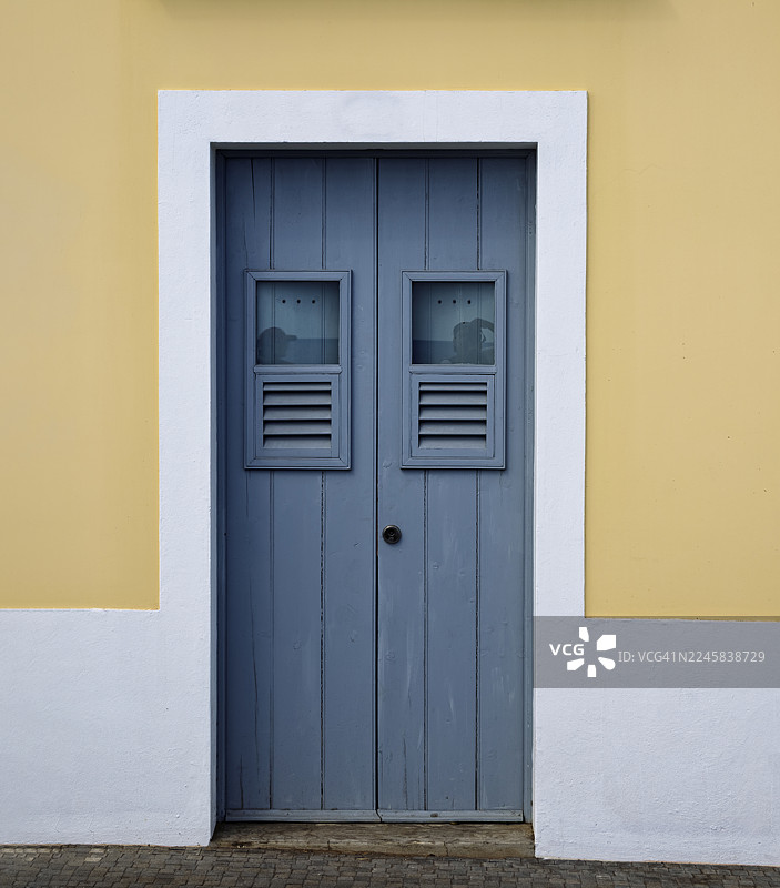 阳光照耀下的老木门房屋外观。图片素材