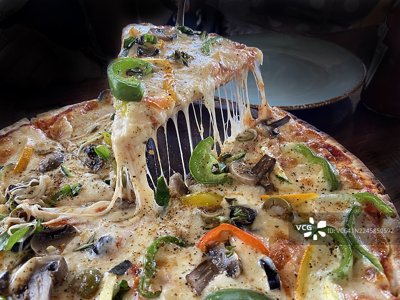 拉起一片正在融化芝士的披萨图片素材