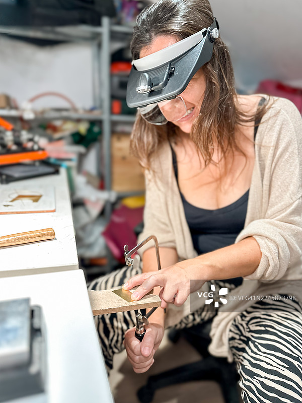 珠宝工匠在工作室里使用精密工具工作图片素材