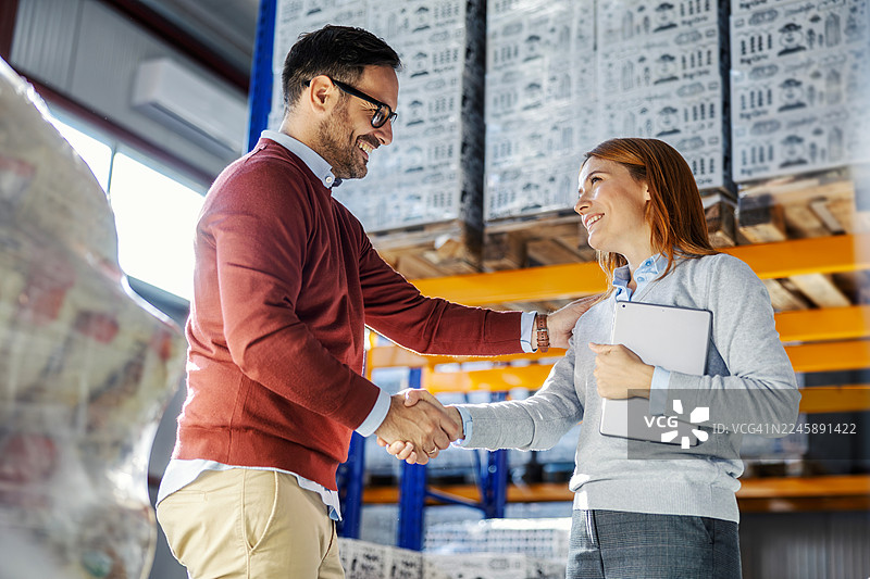 商业伙伴在配送仓库握手图片素材