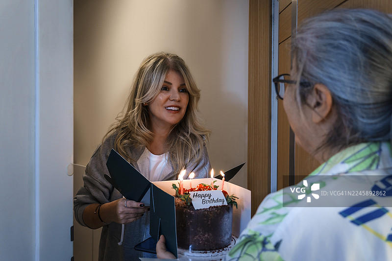 女人给朋友惊喜，送上生日蛋糕和礼物图片素材