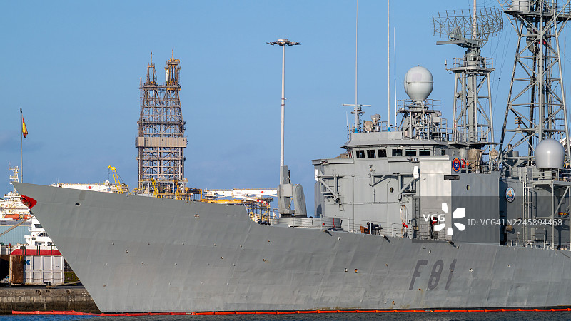 西班牙海军的F-81护卫舰停泊在港口，背景是钻井平台图片素材