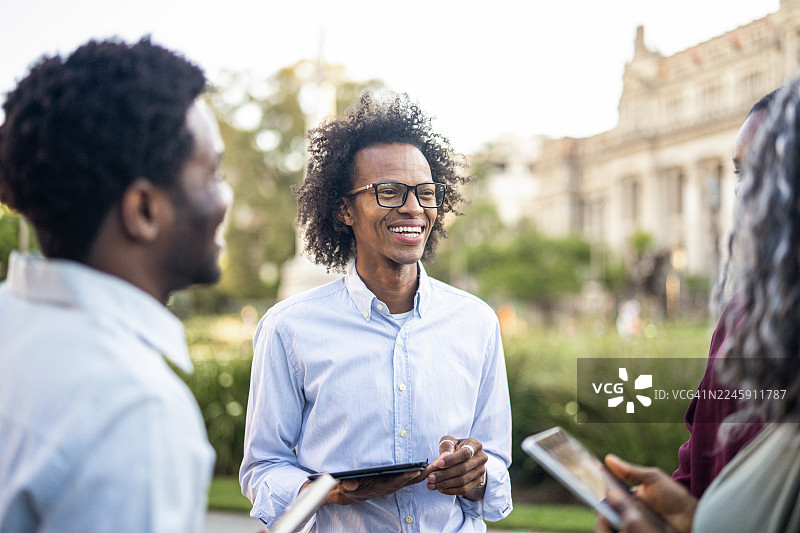 一群黑人商界人士在金融区的街道上举行会议。图片素材
