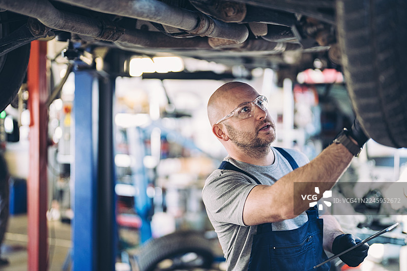 机械师使用平板电脑检查汽车图片素材