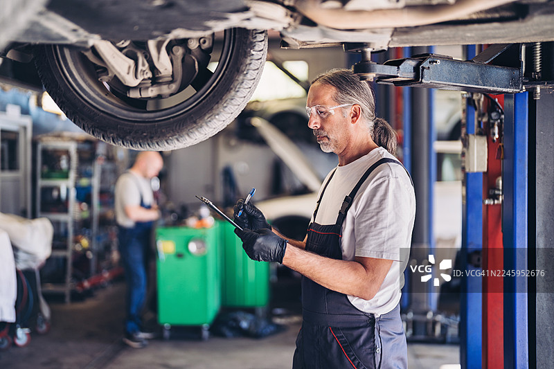 汽车修理工正在撰写维修报告图片素材