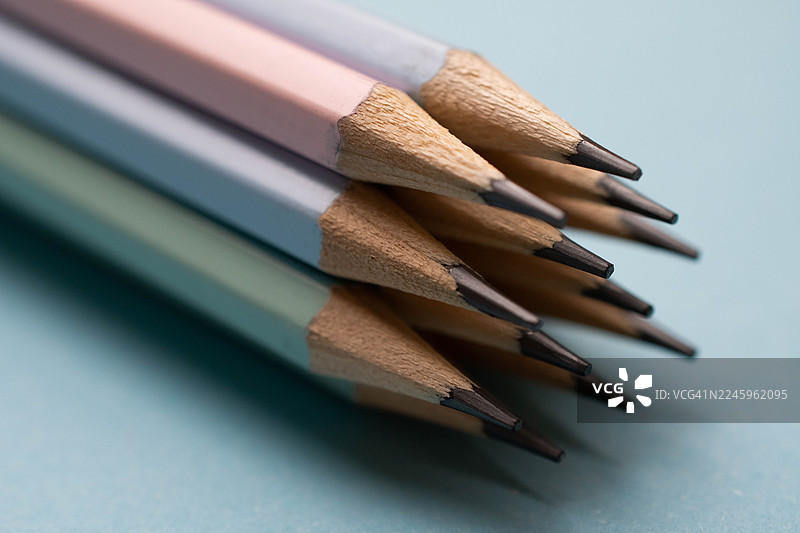 粉蓝色背景上的叠放的铅笔图片素材