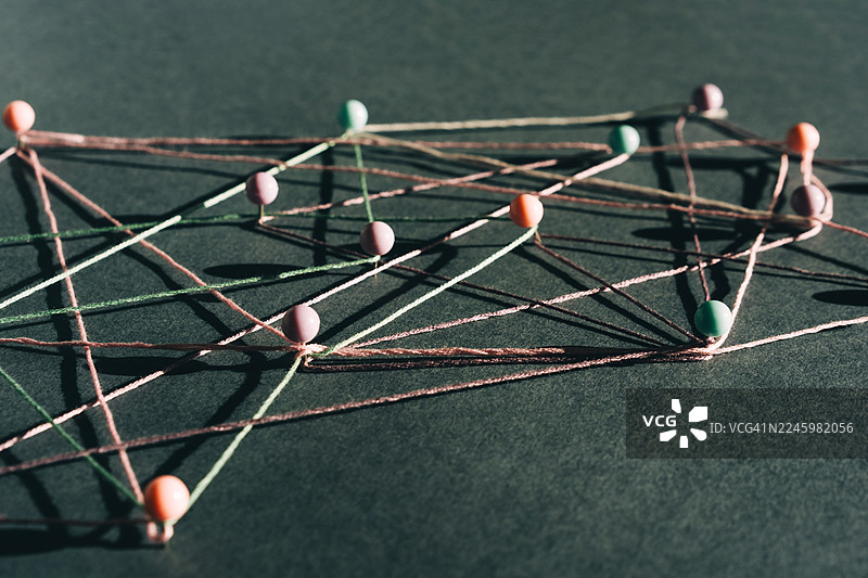 黑暗颓废的意境，彩色的线和针在黑色表面上组成几何网状结构，光影对比强烈。象征着连接的概念。图片素材