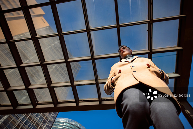 从低角度拍摄，一名商人正走下通往柏林波茨坦广场地铁站的楼梯图片素材