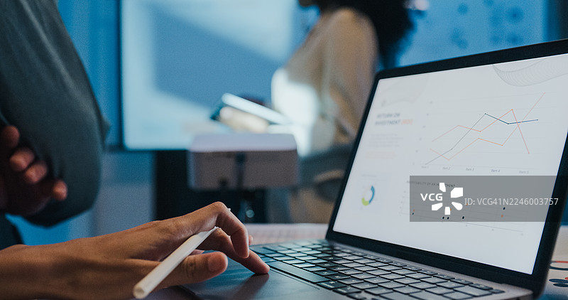 特写：多元化的金融团队商务会议，领导在办公室夜晚展示投资策略和预算计划。市场营销策略分析，股票市场交易，财务顾问概念。图片素材