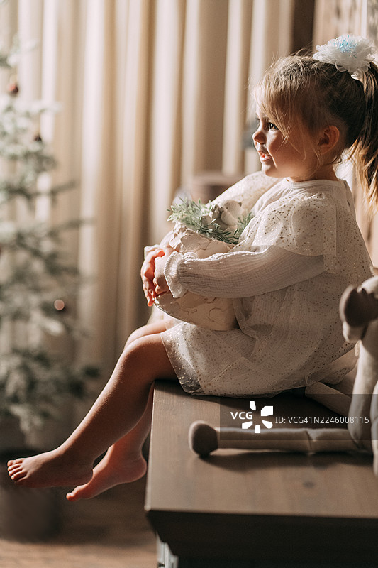 小女孩微笑着收到圣诞礼物，脸上洋溢着幸福感图片素材