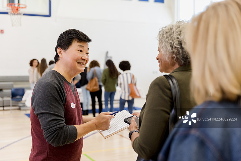 不同肤色的微笑人士在体育馆内交谈。图片素材
