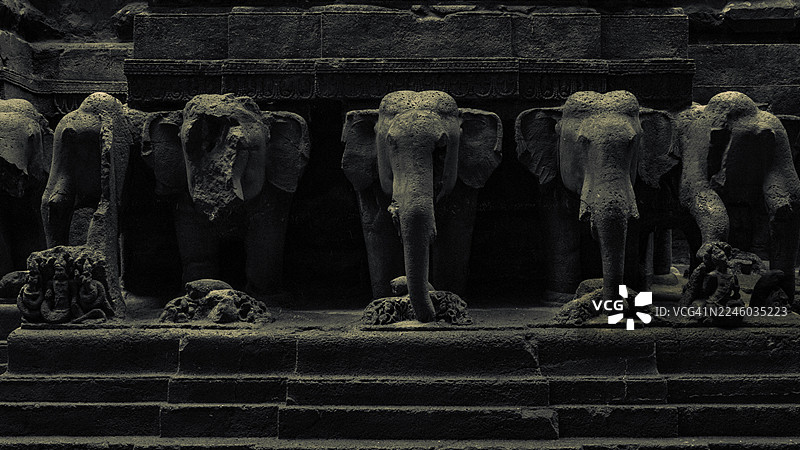 古老的石象雕塑装饰着一座历史寺庙的外墙，展示着精美的雕刻和建筑细节，地点：库尔德哈巴德，印度，维鲁尔图片素材