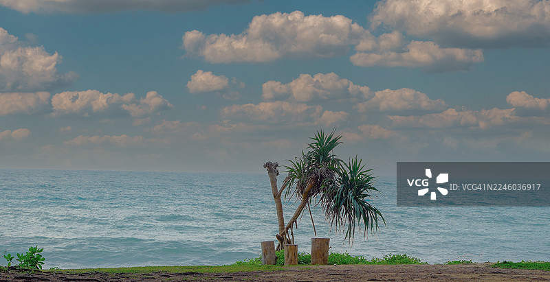 泰国，海边郁郁葱葱的绿色植被，映衬着广阔的蓝色海洋和多云的天空图片素材