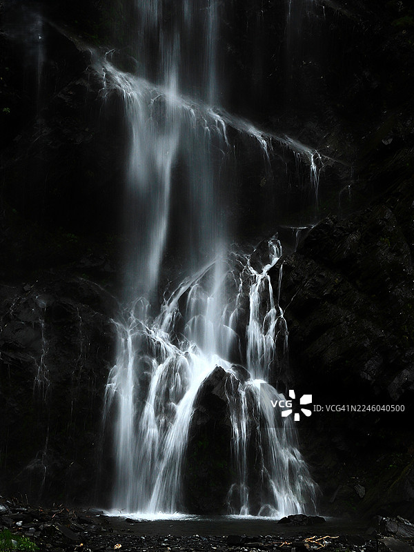 美国瓦尔迪兹宁静森林中，瀑布从黑色岩石上倾泻而下的长曝光戏剧性影像，新娘面纱瀑布图片素材
