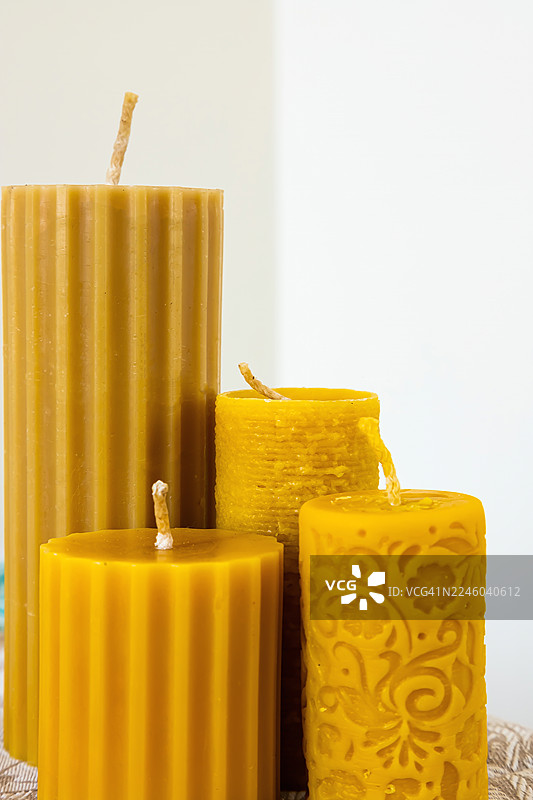 白色背景下，特写一系列具有不同纹理和图案的天然蜂蜡蜡烛。图片素材