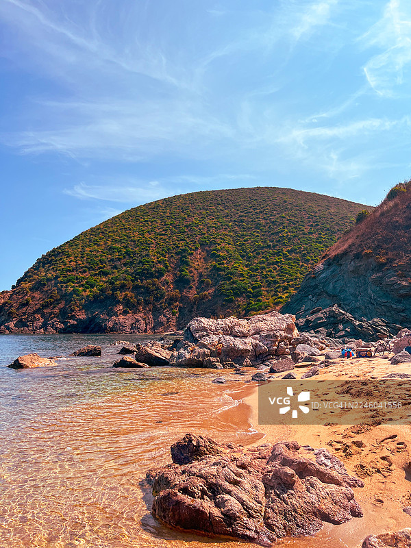 阿尔及利亚斯基克达岩石海滩的风景，海水清澈，绿山郁郁葱葱，蓝天白云图片素材
