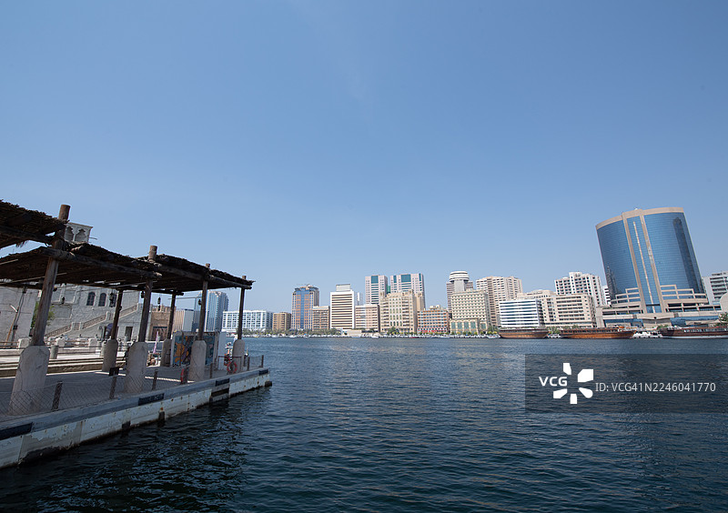 迪拜河，传统阿布拉船码头与现代城市天际线，迪拜，阿拉伯联合酋长国，布尔迪拜图片素材