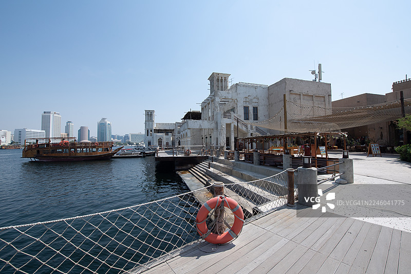 迪拜传统船只和现代城市天际线历史悠久的海滨，阿联酋迪拜，迪拜，阿拉伯联合酋长国，布尔迪拜图片素材