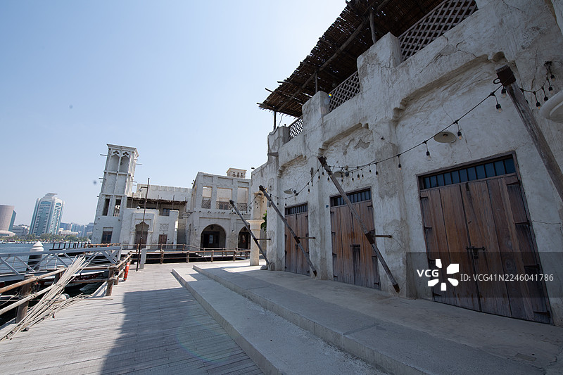 迪拜传统建筑之间的空旷小巷，背景为现代城市天际线，阿联酋迪拜，迪拜，阿拉伯联合酋长国，布尔迪拜图片素材