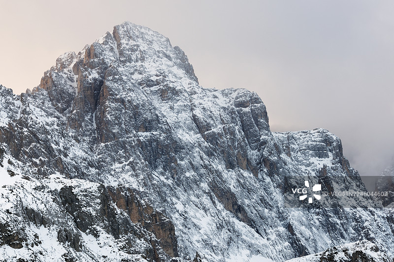 壮丽的雪山之巅，戏剧性的天空下，展示着冬季大自然的粗犷之美，意大利，印尼琴，塞斯托多洛米蒂自然公园图片素材