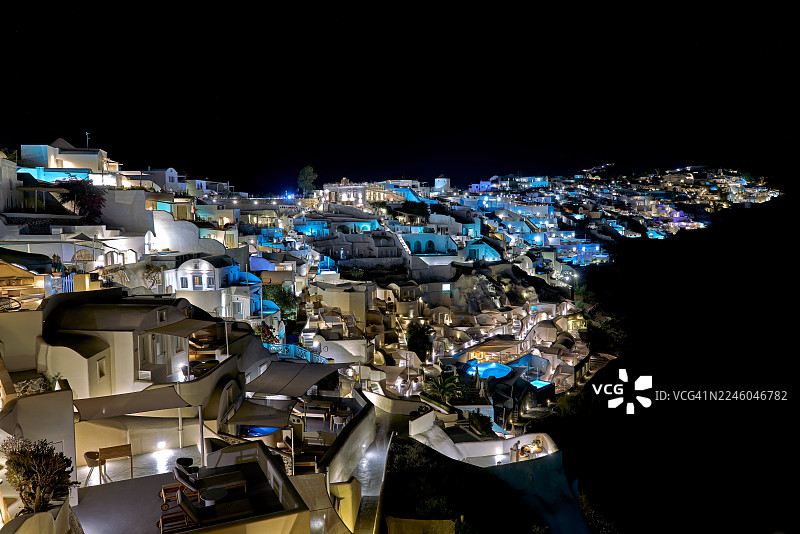 夜间希腊圣托里尼伊亚岛灯火辉煌的建筑和房屋的高角度视图，展示了充满活力和浪漫的城市景观，圣托里尼，希腊图片素材