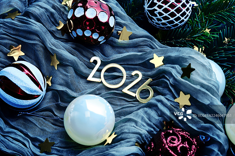 蓝色纺织品上的圣诞装饰和2026数字的高角度视图，象征着新年庆祝和未来的节日图片素材