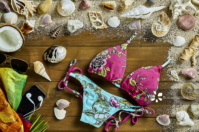 质朴的木质背景上的海滩用品、贝壳和沙子的俯视图图片素材