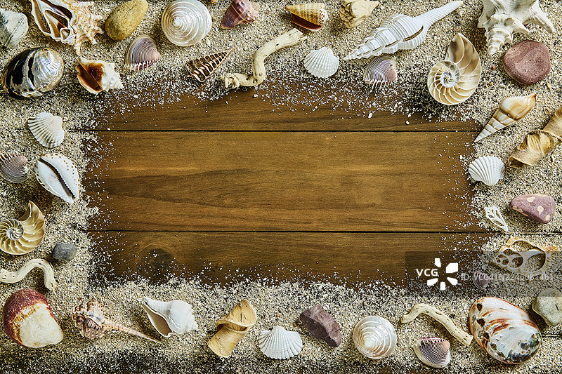 质朴的木质背景上的贝壳和沙子的俯视图图片素材