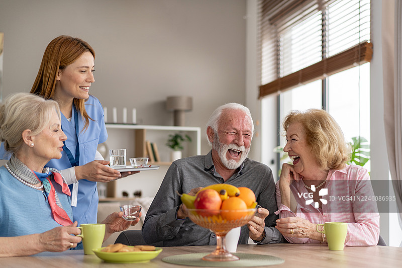 老年人在早餐桌上分享欢笑和饮品图片素材