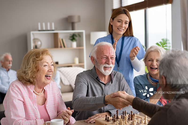 老年人在下棋时开心地握手图片素材