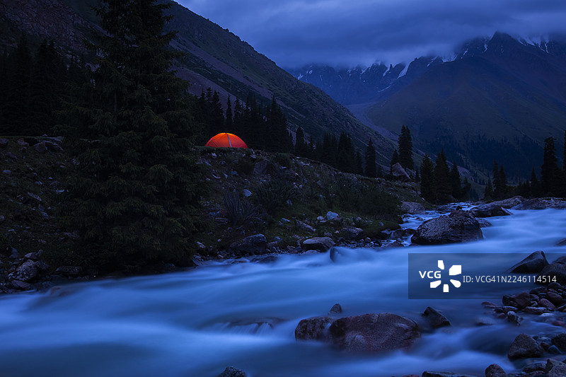 夜晚，帐篷位于河岸的山区。图片素材