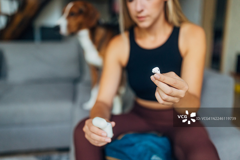 一位女士准备徒步旅行，她手中拿着无线耳机，特写镜头图片素材