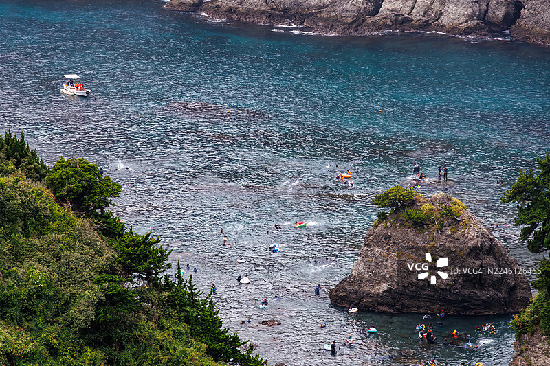 从海角天文台俯瞰的日向滩美丽蔚蓝的海景。可以看到鬼岛等无人岛、小岛以及当地的岩石海岸。潜水员和浮潜者乘坐渔船在海上穿行。图片素材