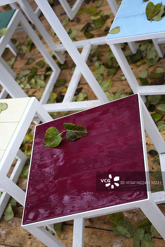 秋日雨中，人去楼空的露天咖啡馆，桌上落满落叶图片素材