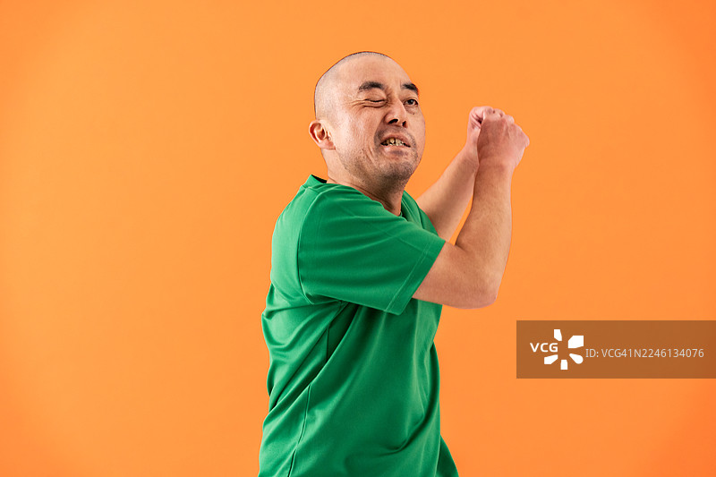 一位40多岁的日本男性，面部左侧瘫痪，正在跳舞，工作室肖像。图片素材