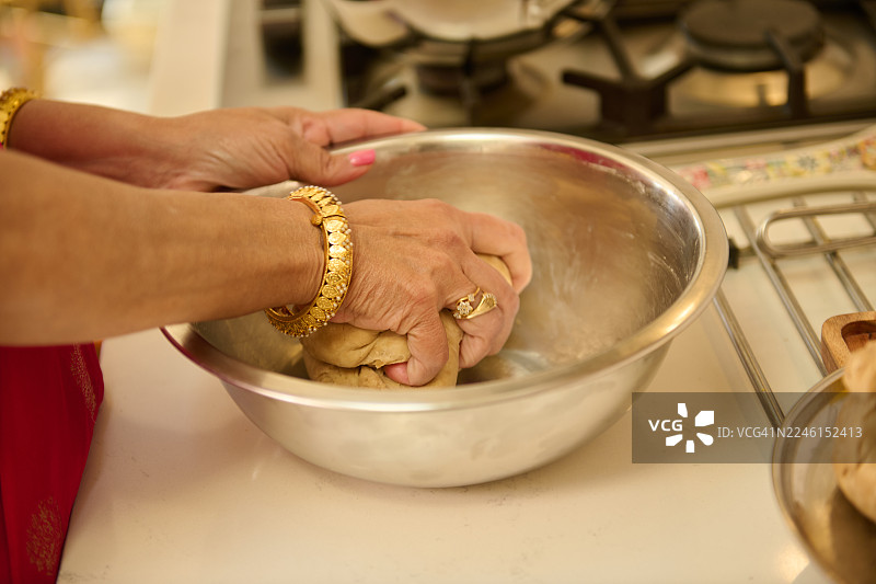 在家里的厨房里，有人在碗里揉面团图片素材