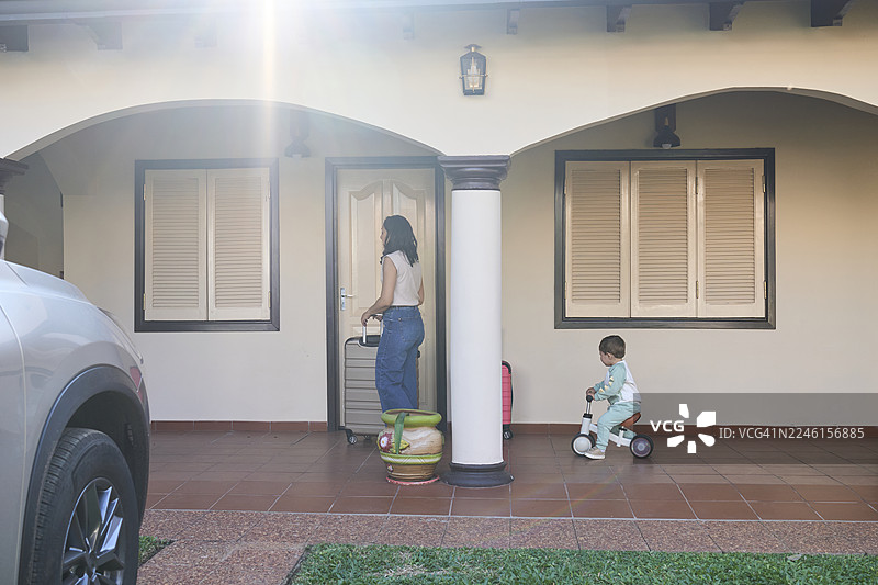 母亲和儿子带着行李回到家图片素材