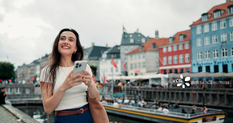 游客在城市中边走边用智能手机搜索网页和在线地图，为夏日假期进行数字地图导航和思考。图片素材