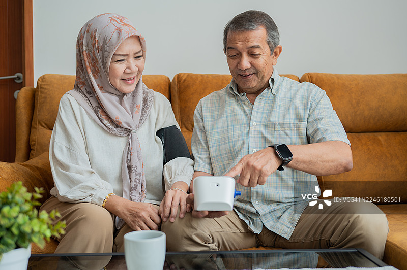 亚洲老年夫妇在家使用医疗设备测量血压的素材照片图片素材