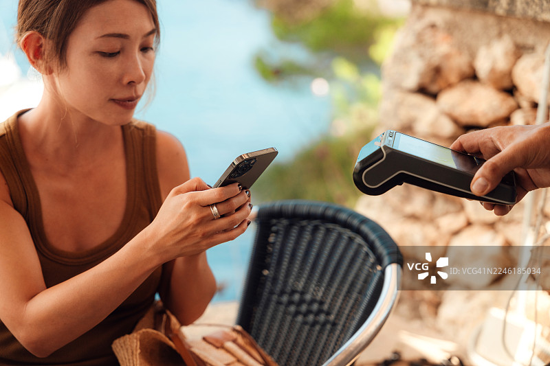 年轻亚洲女性在餐厅用信用卡付款图片素材