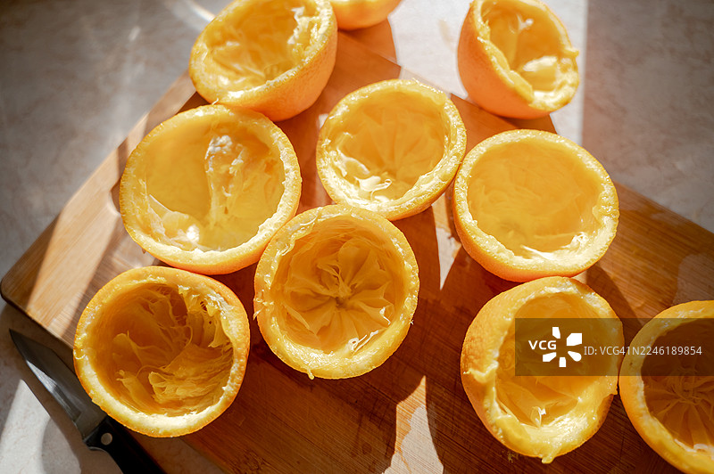 阳光下桌上挤压过的橙子对半切图片素材