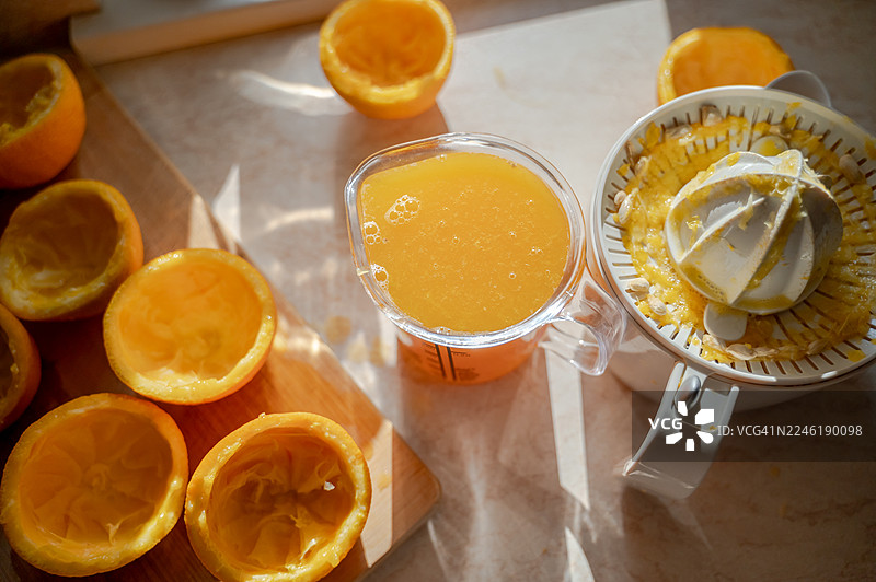 阳光明媚的桌子上放着一壶新鲜的橙汁图片素材