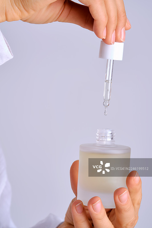 女性用滴管涂抹护肤精华图片素材