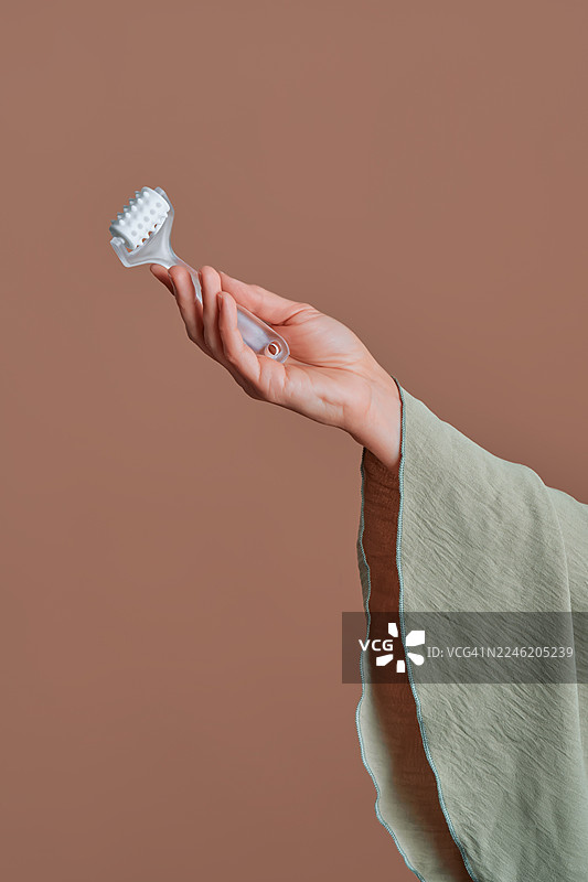 手持面部按摩仪进行自我护理图片素材