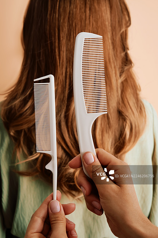 理发师在女子长发前展示梳子图片素材